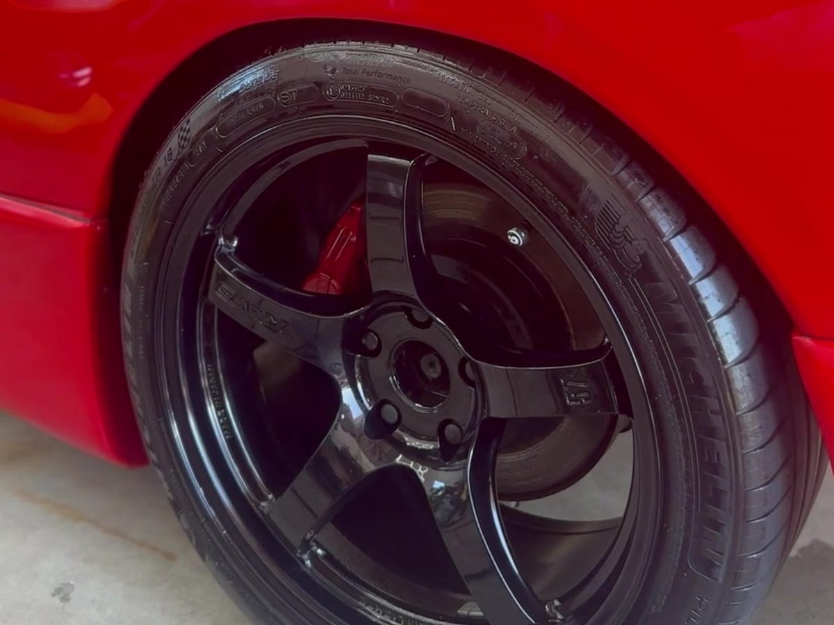 Black alloy wheel and tyre on a red car, cleaned and dressed