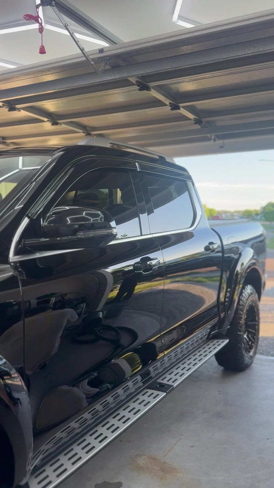Black ute with a deep gloss finish parked under a carport